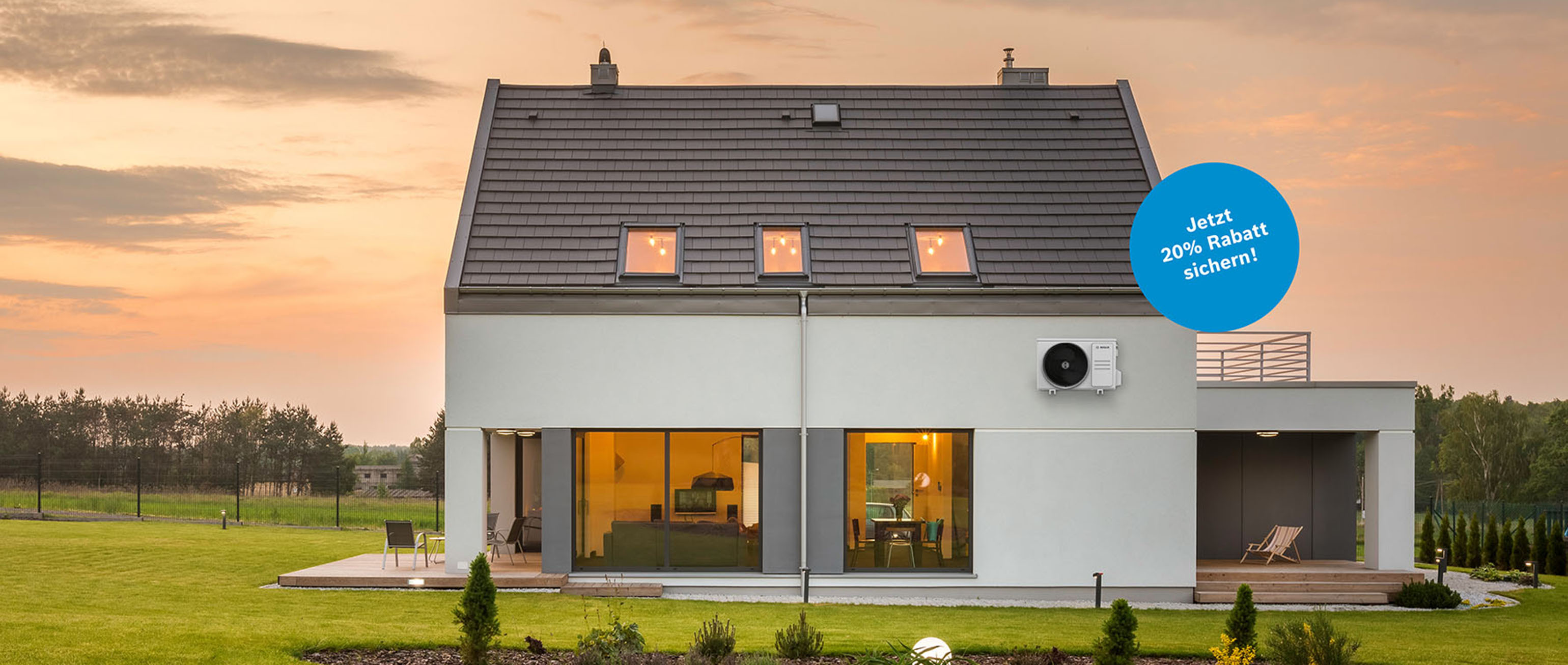 Modernes zweist&ouml;ckiges Haus bei Sonnenuntergang mit gro&szlig;en Fenstern und einem Innenhof. Ein blaues, kreisf&ouml;rmiges Etikett in deutscher Sprache bietet einen Rabatt von 20 %. Das Haus ist von Gras und Pflanzen umgeben, mit B&auml;umen und Feldern im Hintergrund.